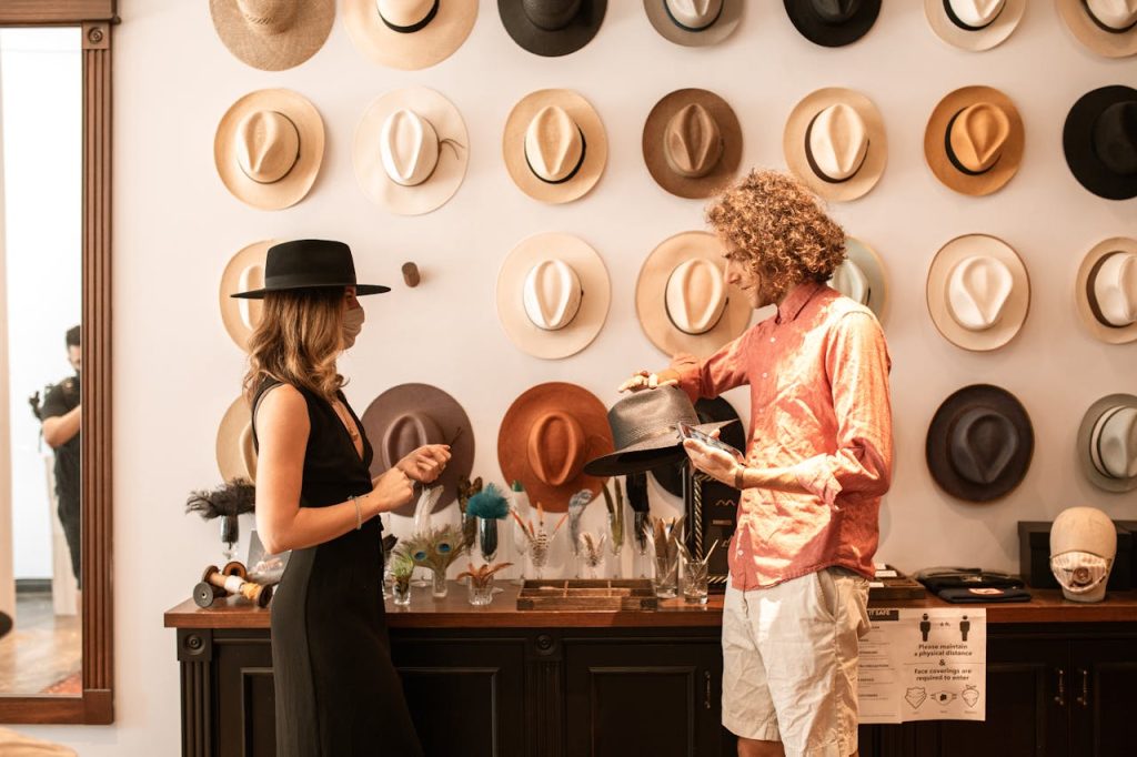 A stylish couple exploring a variety of fashionable hats in an elegant boutique setting.