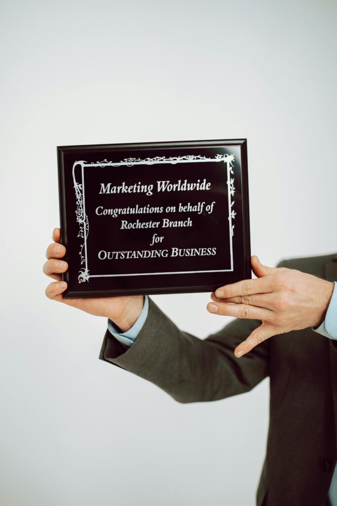 Close-up of hands holding a business award plaque for outstanding achievements.