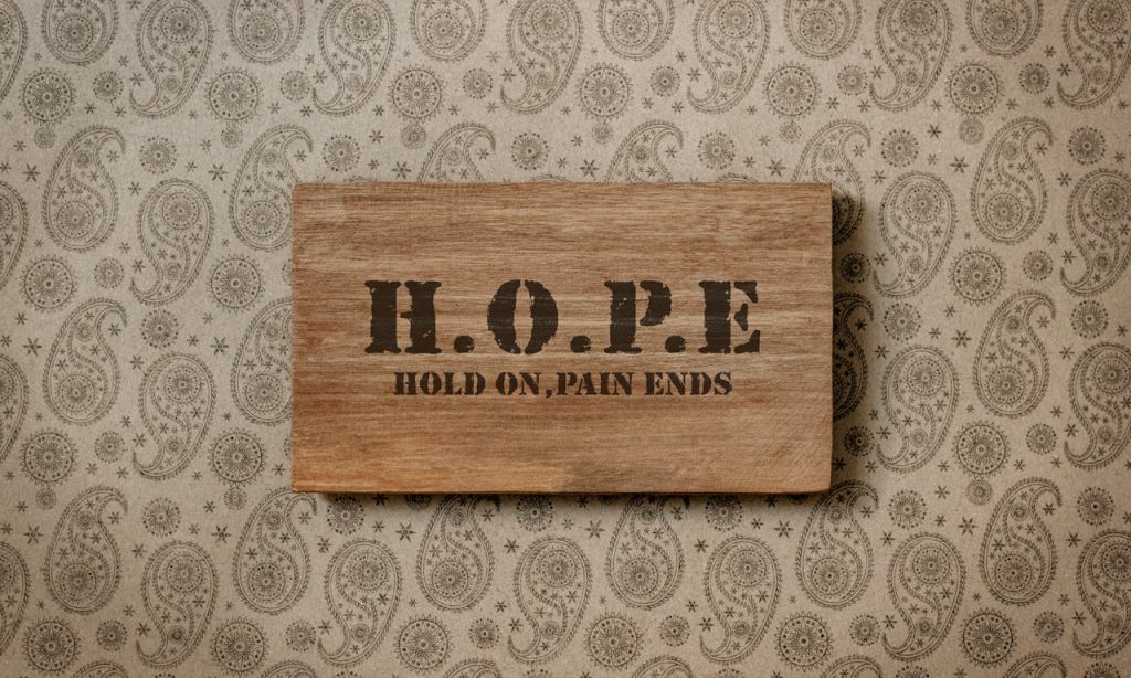 Rustic wooden sign with motivational H.O.P.E message on patterned wallpaper.